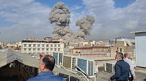 AP : People watch as smoke rises on the skyline after an explosion in Tehran, Iran.