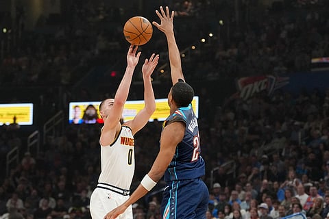 Denver Nuggets guard Christian Braun, left, shoots over Oklahoma City Thunder guard Aaron Wiggins, right, during the first half of an NBA basketball game in Oklahoma City.