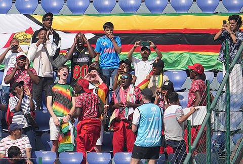 Zimbabwe supporters cheer with their national flag before the start of the T20 World Cup cricket match between South Africa and Zimbabwe in New Delhi.