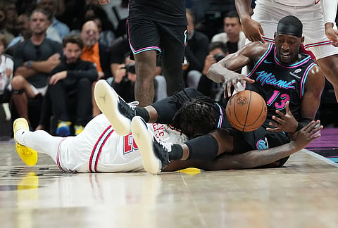 Miami Heat center Bam Adebayo (13) sndf Houston Rockets forward Dorian Finney-Smith, left go for a loose ball during the second half of an NBA basketball game, in Miami.