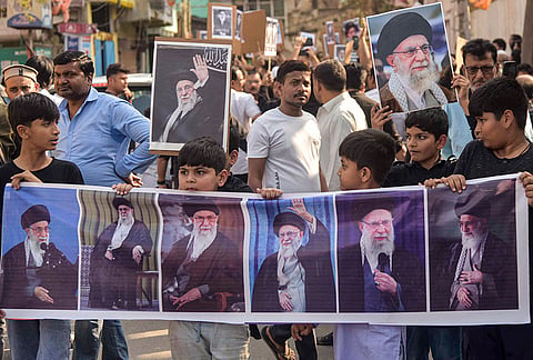 People hold portraits of Iran's Supreme Leader Ayatollah Ali Khamenei during a protest following his alleged killing in a US-Israel strike, in Patna.
