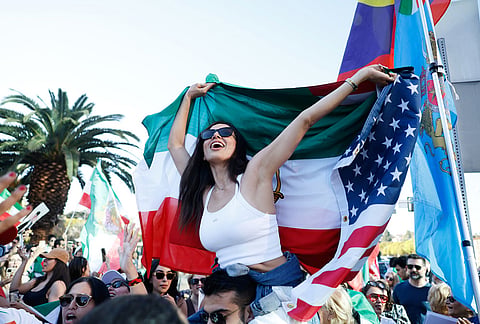 People hold flags during a demonstration in reaction to the U.S. and Israeli strikes on Iran in Los Angeles. 
