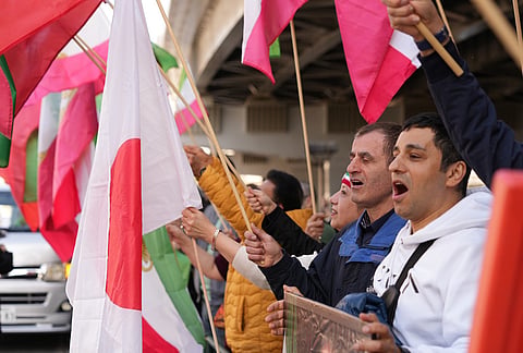 Iranians living in Japan and their families gather near the Iranian Embassy in Tokyo to show support Saturday's U.S.-Israel strikes on Iran. 