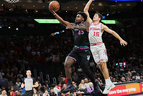 Miami Heat guard Davion Mitchell (45) goes to the basket as Houston Rockets guard Reed Sheppard (15) defends during the first half of an NBA basketball game, in Miami.