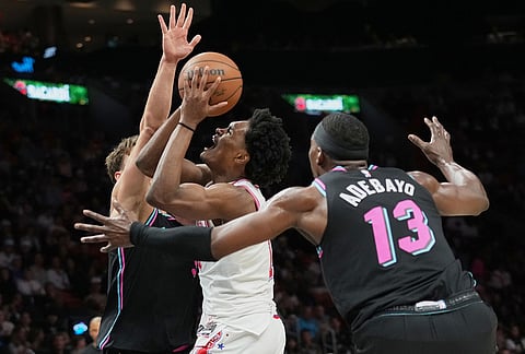 Houston Rockets guard Amen Thompson, center goes to the basket as Miami Heat guard Pelle Larsson, left, and center Bam Adebayo (13) defend during the second half of an NBA basketball game in Miami.