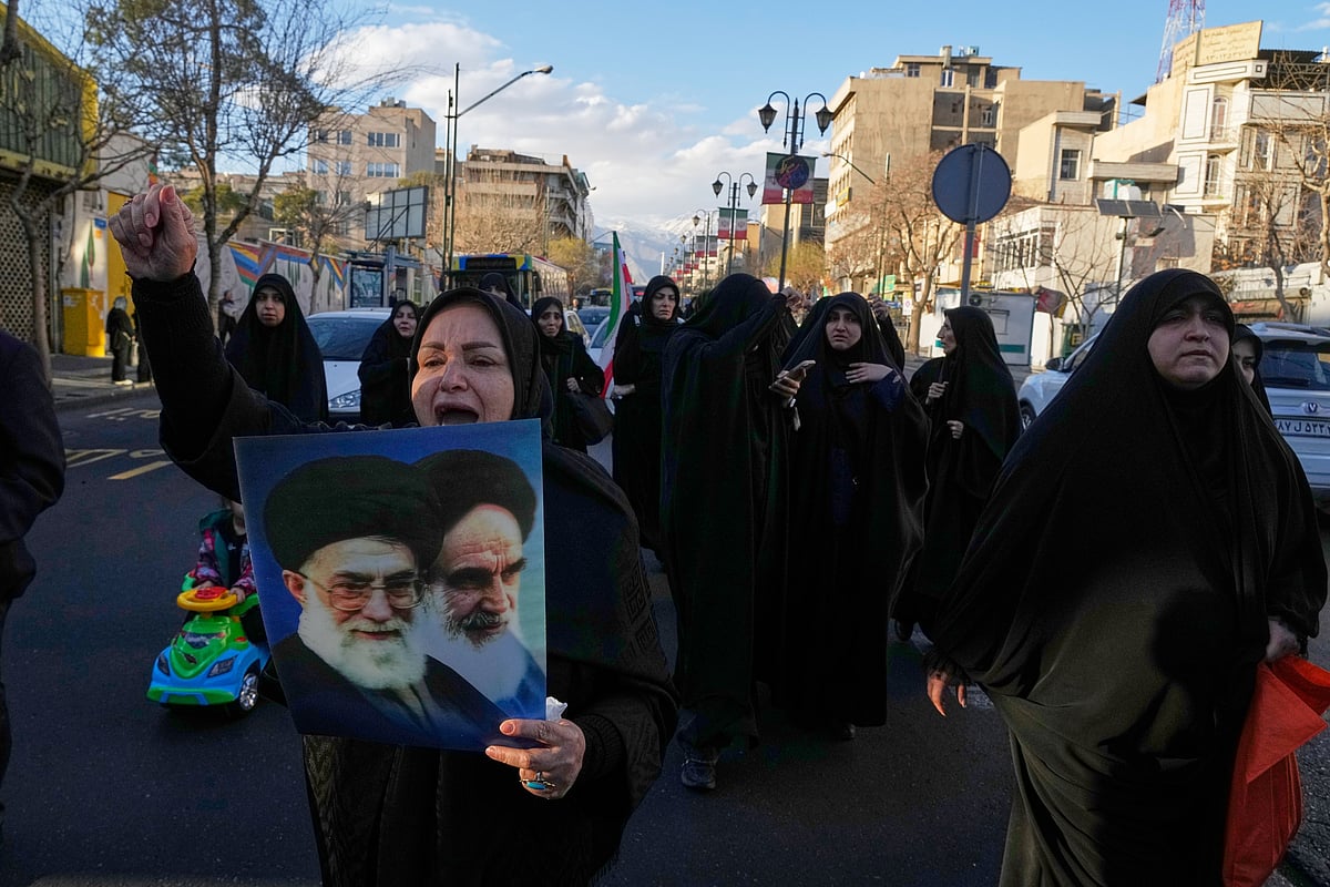 AP Photo/Vahid Salemi : A woman holds pictures of Ayatollah Khomeini and the late Iranian Supreme Leader Ayatollah Ali Khamenei as a group of government supporters march toward Khamenei's residency in Tehran, Iran, Sunday, March 1, 2026, following the confirmed death of Khamenei in U.S. and Israeli strikes