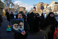 Iran Health Official Says Supreme Leader Suffered Only ‘Superficial’ Wounds In U.S.-Israel Strike AP Photo/Vahid Salemi : A woman holds pictures of Ayatollah Khomeini and the late Iranian Supreme Leader Ayatollah Ali Khamenei as a group of government supporters march toward Khamenei's residency in Tehran, Iran, Sunday, March 1, 2026, following the confirmed death of Khamenei in U.S. and Israeli strikes