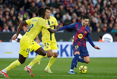 Barcelona's Roony Bardghji, right, dribbles the ball past Villarreal's Pape Gueye (18) and Alfonso Pedraza during the Spanish La Liga soccer match between Barcelona and Villareal in Barcelona, Spain.