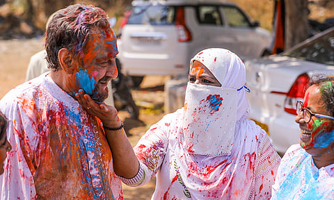 A woman applies colours to Nawab Raunaq Yar Khan during Holi celebrations at his residence, in Hyderabad.