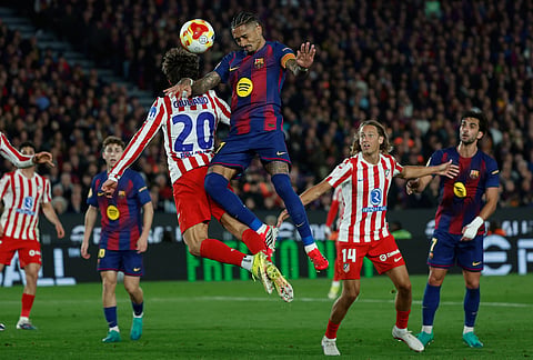 Atletico Madrid's Giuliano Simeone, left, and Barcelona's Raphinha challenge for the ball during the Copa del Rey semifinal second leg soccer match between Barcelona and Atletico Madrid in Barcelona, Spain.