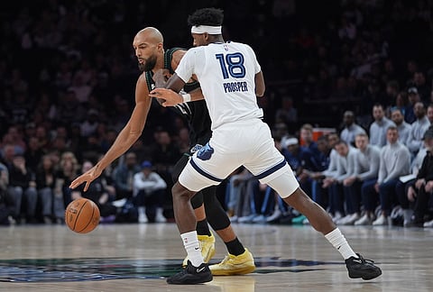 Minnesota Timberwolves center Rudy Gobert works toward the basket as Memphis Grizzlies forward Olivier-Maxence Prosper (18) defends during the first half of an NBA basketball game, in Minneapolis.