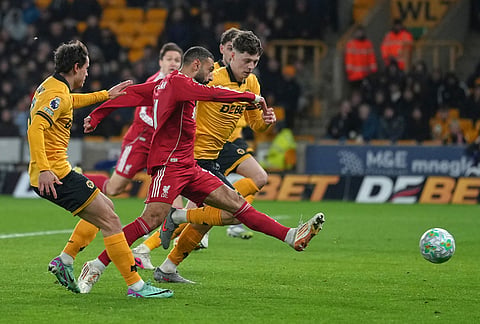 Liverpool's Mohamed Salah scores his side's opening goal during the English Premier League soccer match between Wolverhampton Wanderers and Liverpool in Wolverhampton, England.