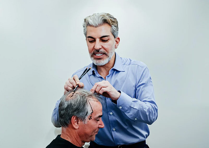 A doctor examining a patients scalp before a hair transplant procedure.