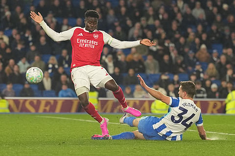 Brighton's Joel Veltman tackles Arsenal's Bukayo Saka during the Premier League soccer match between Brighton and Arsenal in Brighton, England.