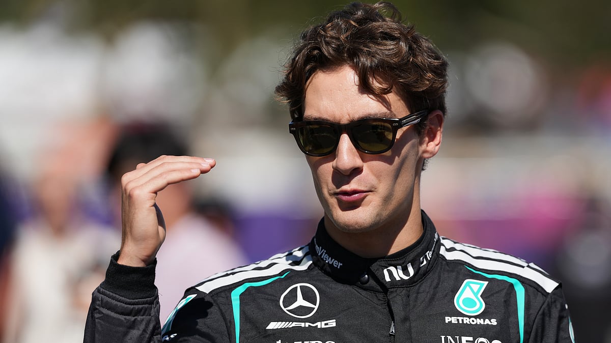 AP/Heath McKinley : Mercedes driver George Russell of Britain gestures as he walks down the F1 Paddock ahead of the Australian Formula One Grand Prix at Albert Park, in Melbourne, Australia.