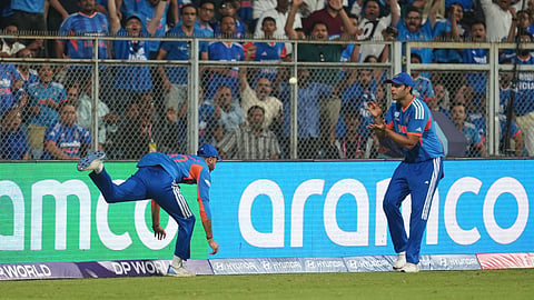 India's Axar Patel, left, passes the ball to teammate Shivam Dube to dismiss England's Will Jacks during the T20 World Cup cricket semi-final match between India and England in Mumbai, India, Thursday, March 5, 2026.