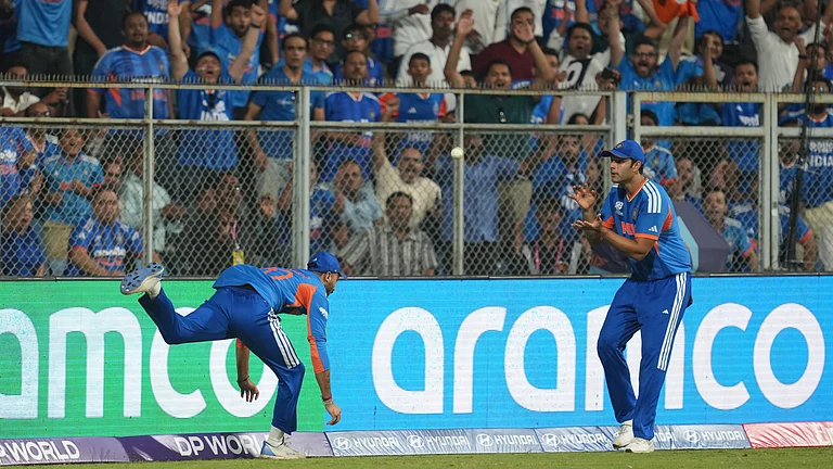India's Axar Patel, left, passes the ball to teammate Shivam Dube to dismiss England's Will Jacks during the T20 World Cup cricket semi-final match between India and England in Mumbai, India, Thursday, March 5, 2026. - (AP Photo/Rafiq Maqbool)
