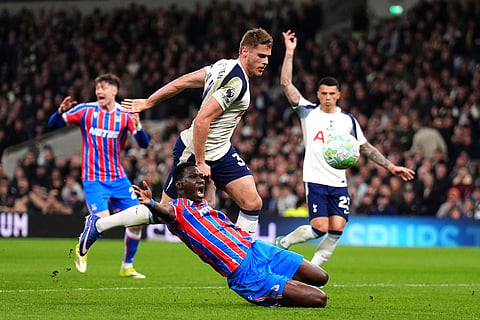 Tottenham Hotspur's Micky van de Ven,top, fouls Crystal Palace's Ismaila Sarr resulting in a red card and a penalty kick during the English Premier League soccer match between Tottenham Hotspur and Crystal Palace in London.