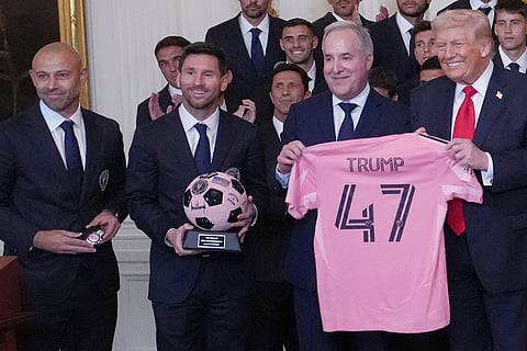 President Donald Trump poses for a photo as head coach Javier Mascherano, Lionel Messi and Inter Miami co-owner Jorge Mas present gifts at an event to honor the 2025 Major League Soccer champions Inter Miami in the East Room of the White House in Washington.