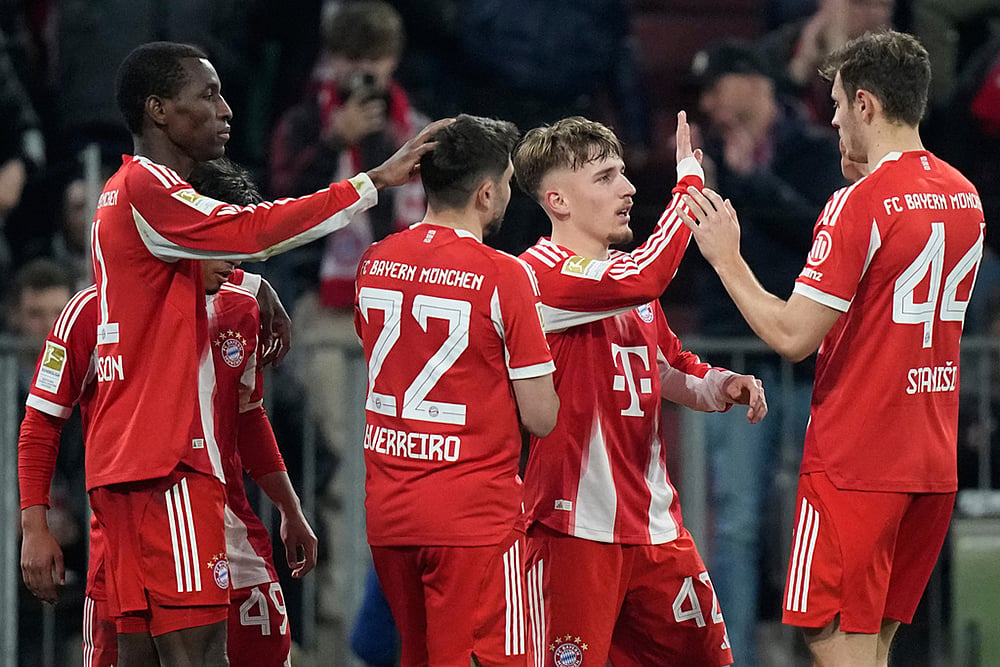 | Photo: AP/Matthias Schrader : Bayern's Nicolas Jackson, left, celebrates with team mates Raphael Guerreiro (22), Lennart Karl (42) and Josip Stanisic (44) after scoring his side's fourth goal during the Bundesliga soccer match between FC Bayern Munich and Borussia Moenchengladbach in Munich, Germany.