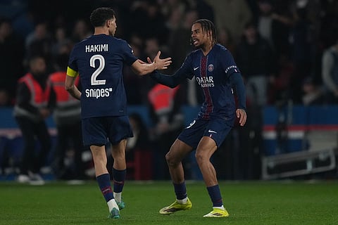 PSG's Bradley Barcola, right, is congratulated by Achraf Hakimi after scoring his side's first goal during the French League One soccer match between Paris Saint-Germain and Monaco in Paris.
