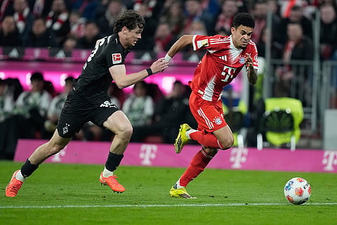 Moenchengladbach's Philipp Sander, left, and Bayern's Luis Diaz challenge for the ball during the Bundesliga soccer match between FC Bayern Munich and Borussia Moenchengladbach in Munich, Germany.