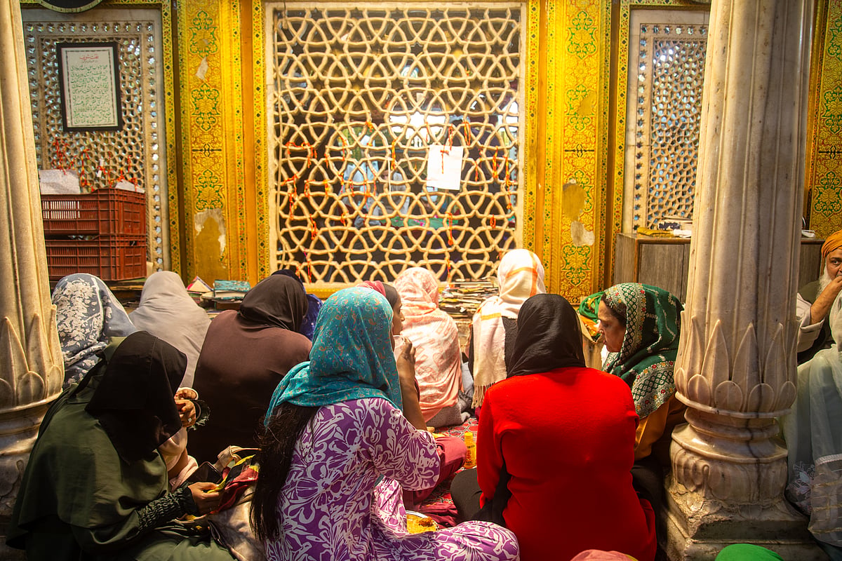 A group of women seated near the wall surrounding the mazar of Khwaja Nizamuddin Auliya 