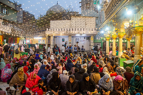 A large gathering for iftar at Nizamuddin Dargah. Women and children sit near the mazar of the Sufi saint Khwaja Nizamuddin Auliya.