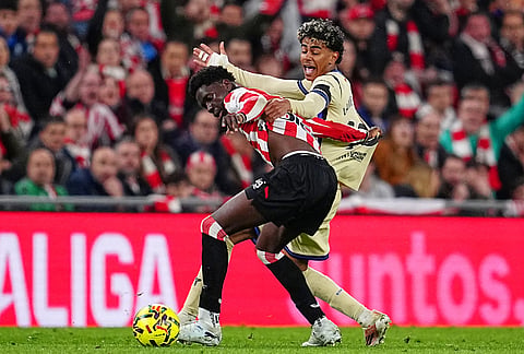 Athletic Bilbao's Adama Boiro, front, and Barcelona's Lamine Yamal vie for the ball during the Spanish La Liga soccer match between Athletic Bilbao and Barcelona in Bilbao, Spain.