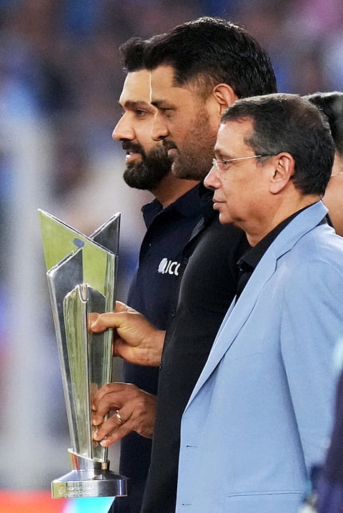 Former India international Rohit Sharma, left, and Mahendra Singh Dhoni, center jointly hold the winner's trophy before the start of the T20 World Cup cricket final match between India and New Zealand in Ahmedabad