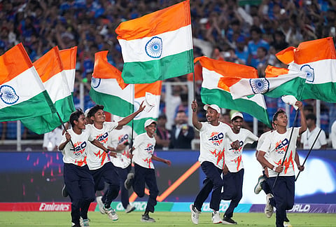 Children run onto the field with Indian national flag after India won the T20 World Cup cricket final match against New Zealand in Ahmedabad.