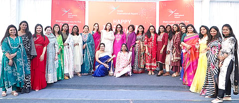 Women workers from various departments pose for a photograph at the upcoming Noida International Airport in Noida, Uttar Pradesh. 