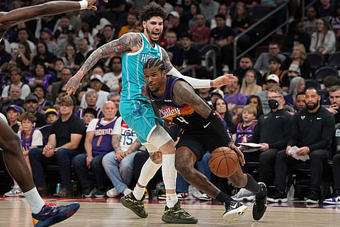 Phoenix Suns guard Jalen Green (4) drives by Charlotte Hornets guard LaMelo Ball during the first half of an NBA basketball game in Phoenix.