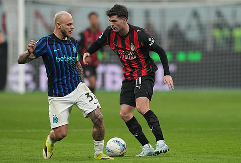 Inter Milan's Federico Dimarco, left, and AC Milan's Christian Pulisic fight for the ball during the Serie A soccer match between AC Milan and Inter Milan, in Milan, Italy.