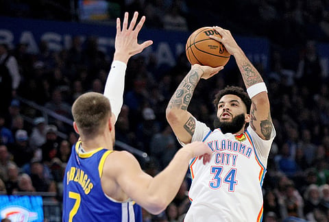Oklahoma City Thunder guard Kenrich Williams (34) looks to shoot over Golden State Warriors center Kristaps Porzingis (7) during the first half of an NBA basketball game in Oklahoma City.
