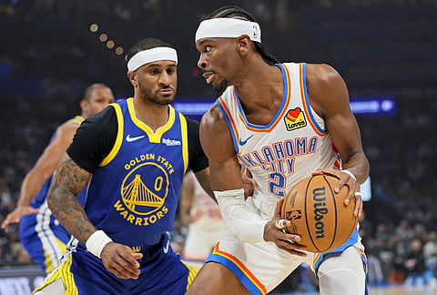 Oklahoma City Thunder guard Shai Gilgeous-Alexander (2) looks for an outlet against Golden State Warriors guard Gary Payton II (0) during the first half of an NBA basketball game in Oklahoma City.  