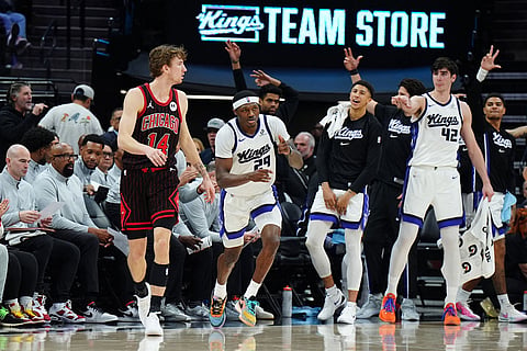 Sacramento Kings guard Daeqwon Plowden (29) and the Kings bench react after Plowden made a basket against the Chicago Bulls during the second half of an NBA basketball game in Sacramento, Calif.