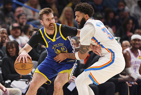 Golden State Warriors guard Pat Spencer (61) handles the ball against Oklahoma City Thunder guard Kenrich Williams, right, during the first half of an NBA basketball game in Oklahoma City. 