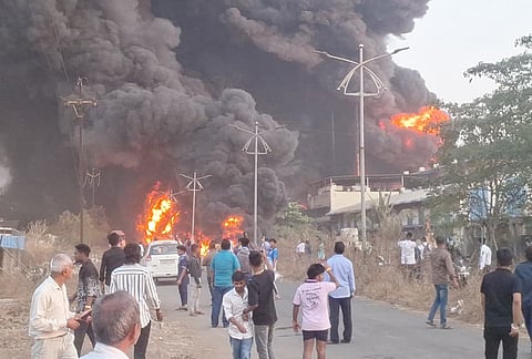 People gather as flames and smoke billow after a massive fire broke out at Shree Ganesh Chemicals Company, in Ambernath, Thane.