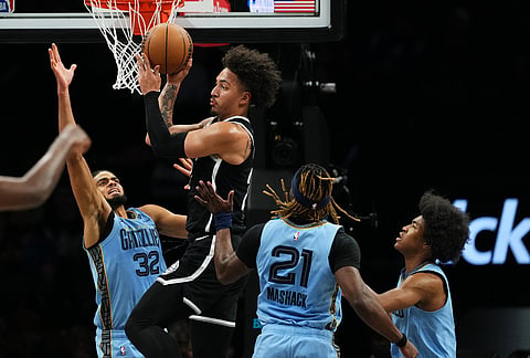 Brooklyn Nets' Jalen Wilson, center, passes away from Memphis Grizzlies' Rayan Rupert, left, and Jahmai Mashack, second from right, and Jaylen Wells, right, during the second half of an NBA basketball game in New York.
