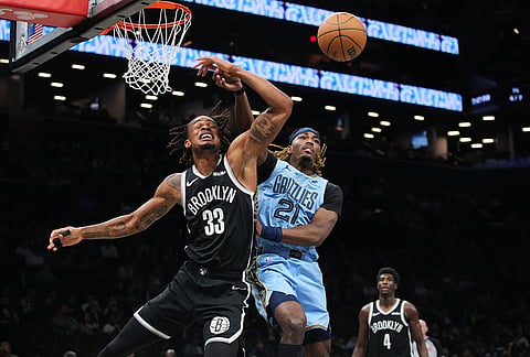 Memphis Grizzlies' Jahmai Mashack (21) defends Brooklyn Nets' Nic Claxton (33) during the first half of an NBA basketball game in New York.