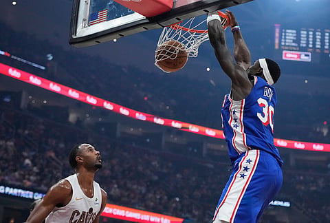 Philadelphia 76ers center Adem Bona (30) dunks in front of Cleveland Cavaliers center Evan Mobley, left, in the second half of an NBA basketball game in Cleveland.