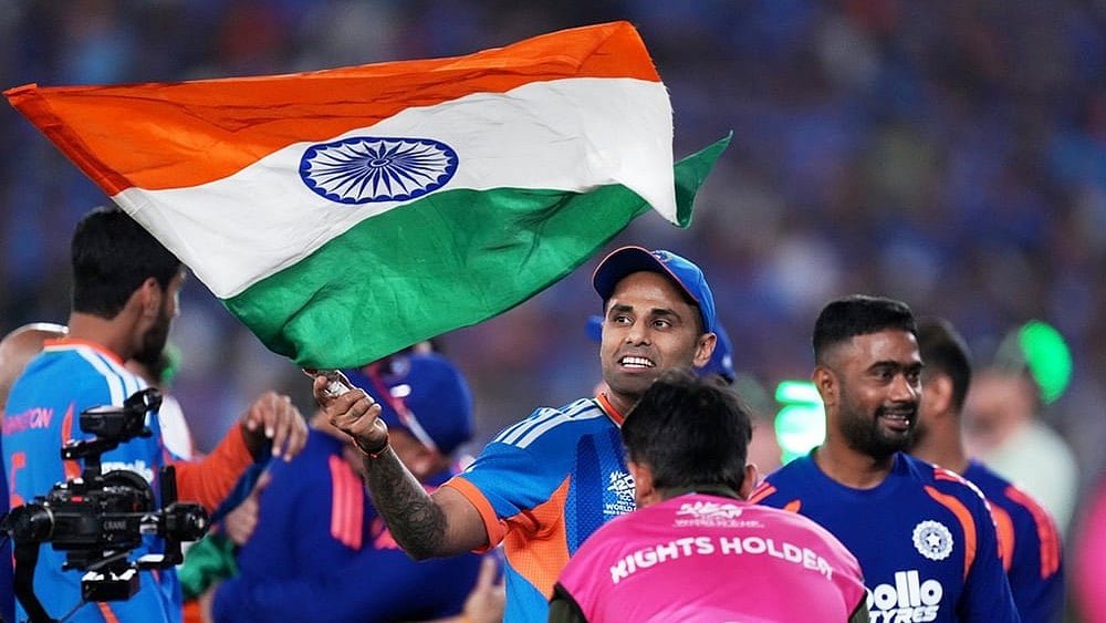 | Photo: AP/Ajit Solanki : India's captain Suryakumar Yadav carries the Indian national flag after winning the T20 World Cup cricket final match against New Zealand in Ahmedabad.