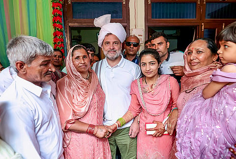Leader of Opposition in the Lok Sabha Rahul Gandhi, centre, poses for photographs as he visits farmer Sanjay Malik's residence to attend his daughter's wedding, in Sonipat, Haryana. 