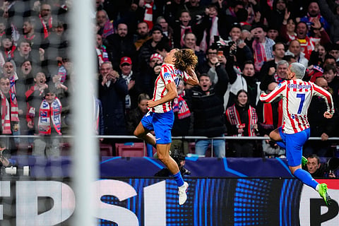 Atletico Madrid's Marcos Llorente, center, celebrates after scoring the opening goal during the first leg of the Champions League round of 16 soccer match between Atletico Madrid and Tottenham in Madrid, Spain.