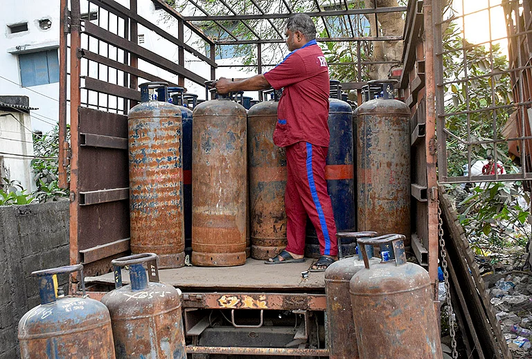 A worker arranges commercial LPG cylinders on a vehicle amid a shortage of cooking gas, in Saroli area of Surat, Gujarat, Tuesday, March 10, 2026. The shortage follows disruptions in LPG supplies linked to the ongoing West Asia conflict affecting global energy supply chains. - | Photo: PTI