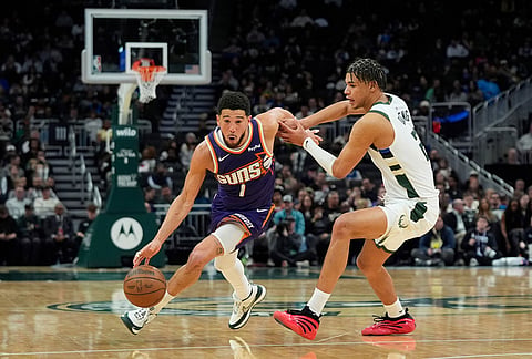 Phoenix Suns' Devin Booker (1) drives to the basket against Milwaukee Bucks' Ousmane Dieng during the second half of an NBA basketball game, in Milwaukee.