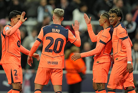 Barcelona's Lamine Yamal, right, celebrates with Raphinha and Dani Olmo after scoring his side's first goal during the Champions League round of 16 first leg soccer match between Newcastle United and Barcelona in Newcastle, England.