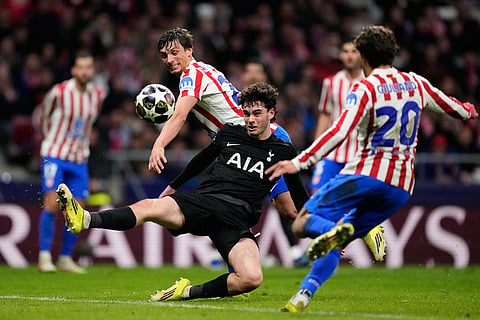 Tottenham's Archie Gray, center, and Atletico Madrid's Robin Le Normand challenge for the ball during the first leg of the Champions League round of 16 soccer match between Atletico Madrid and Tottenham in Madrid, Spain.