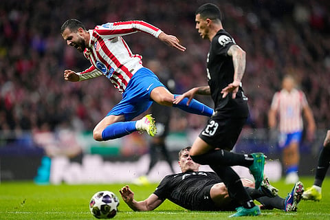 Atletico Madrid's David Hancko, left, challenges for the ball with Tottenham's Micky van de Ven during the first leg of the Champions League round of 16 soccer match between Atletico Madrid and Tottenham in Madrid, Spain.